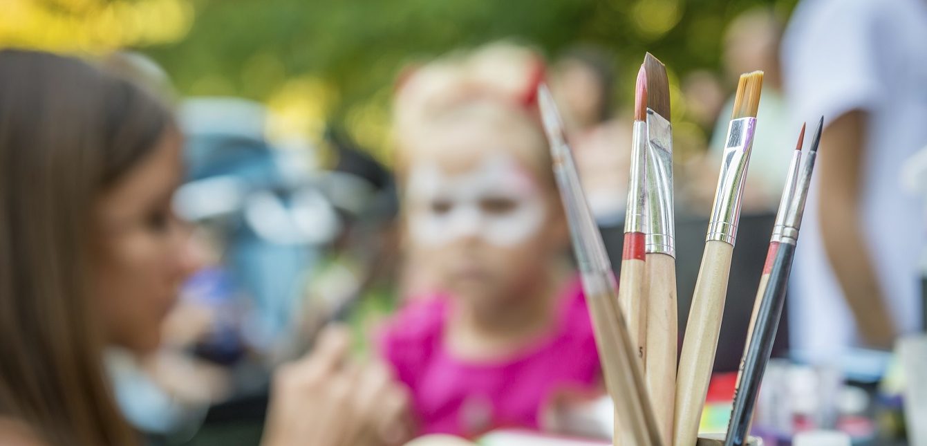 Image of children at a festival with face-painting.